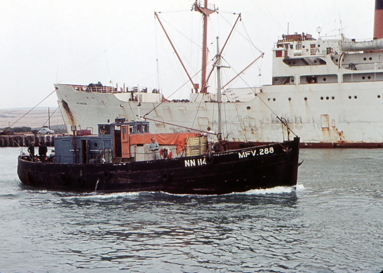 a large white boat with large black sails traveling on the water