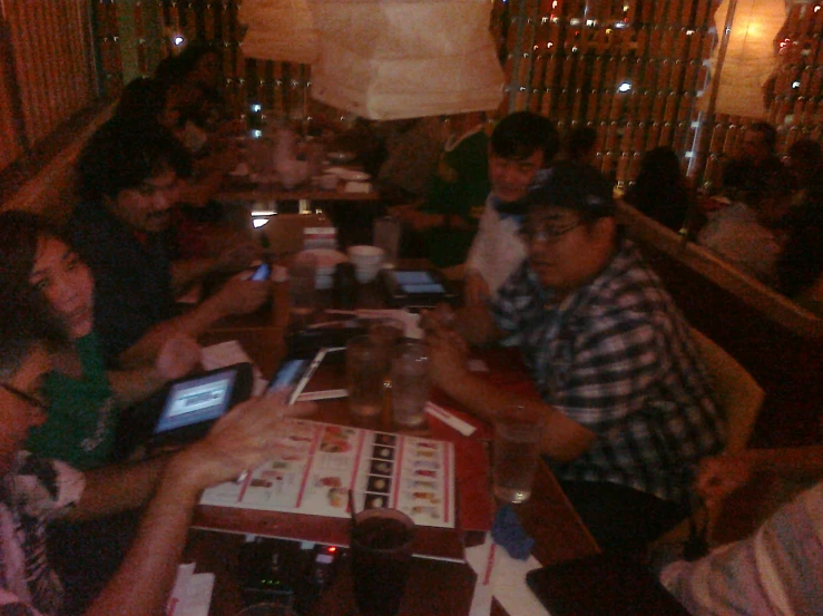 people sitting around a table with cell phones