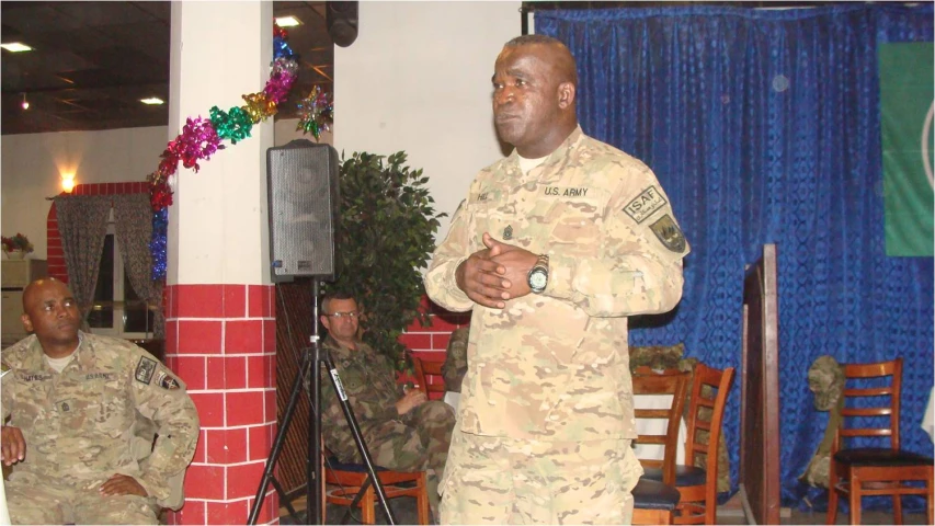 a man in a military uniform standing next to a speaker