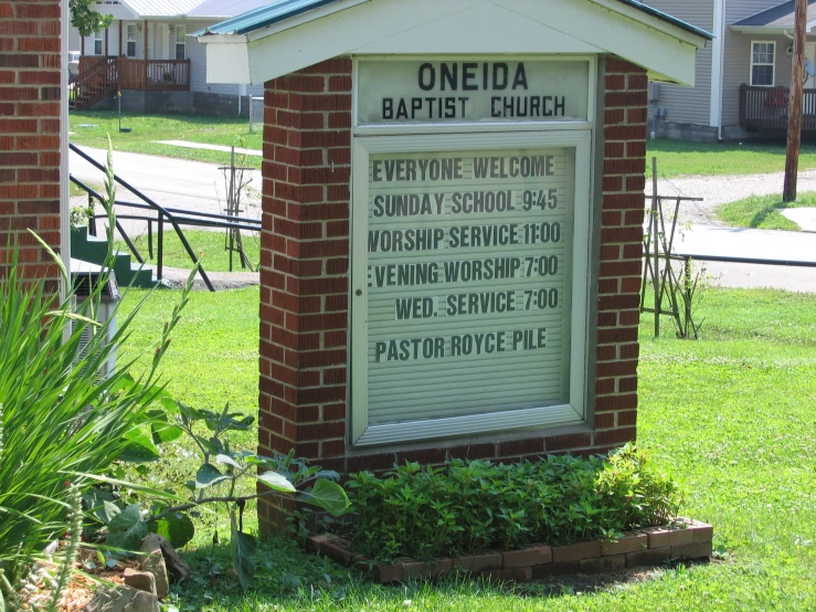 a brick and concrete church sign in the grass