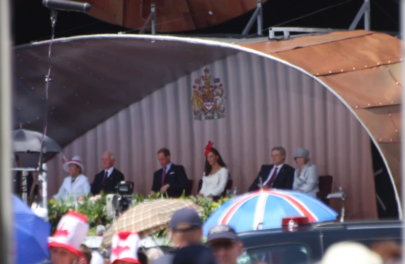 people in the crowd in formal clothes, hats and umbrellas