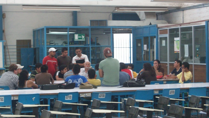 a group of people sitting on some blue chairs