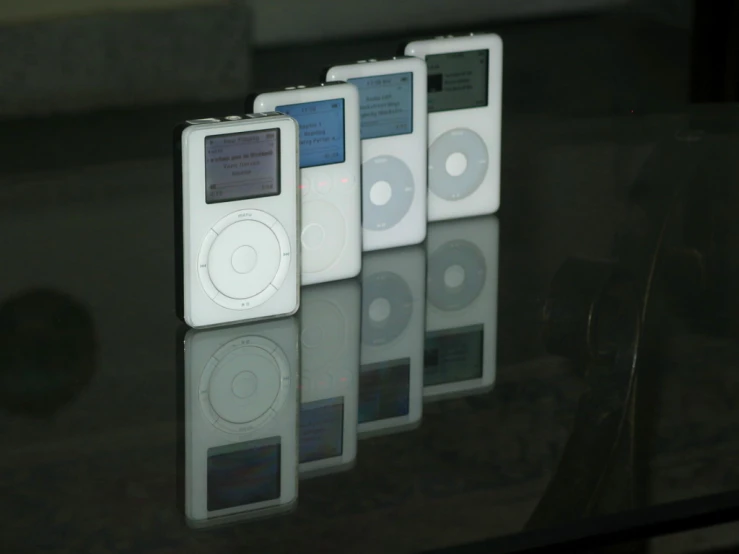 five different white mp3 players lined up next to each other