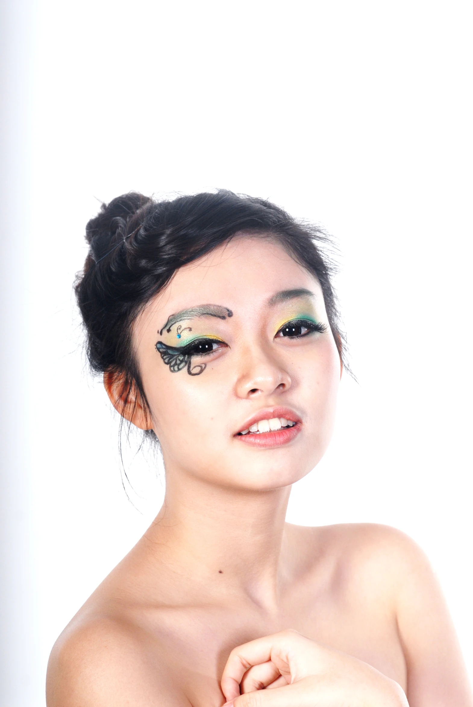 a beautiful asian woman wearing gold and green makeup