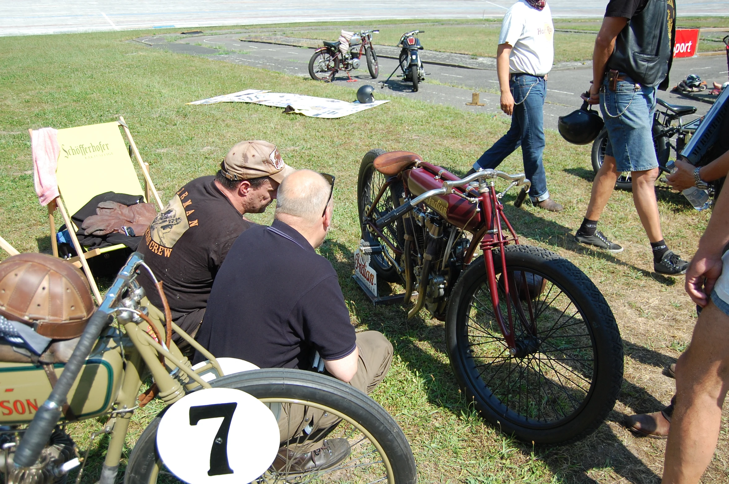 a number of people near many bikes in the grass