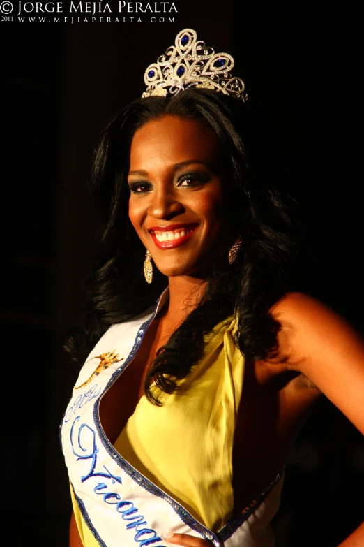 a woman smiling in her miss america competition outfit