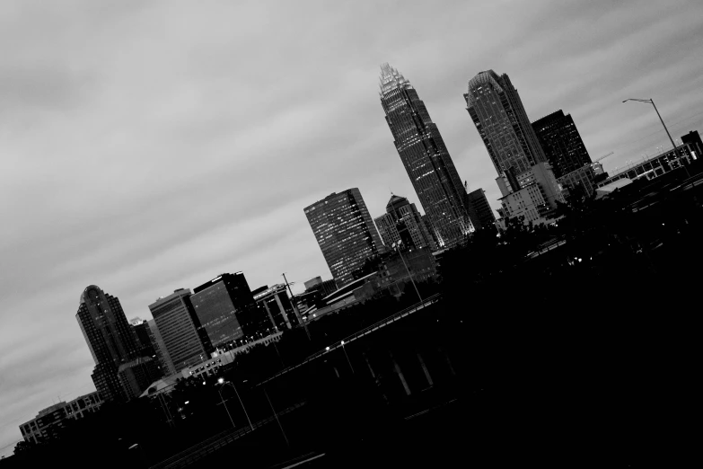 a jetliner is flying through a cloudy sky over a city