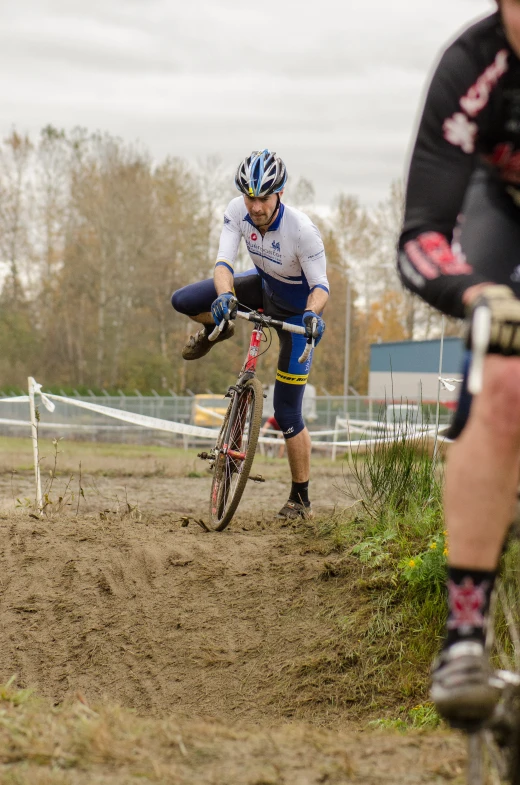 two people in dirt area with bikes around