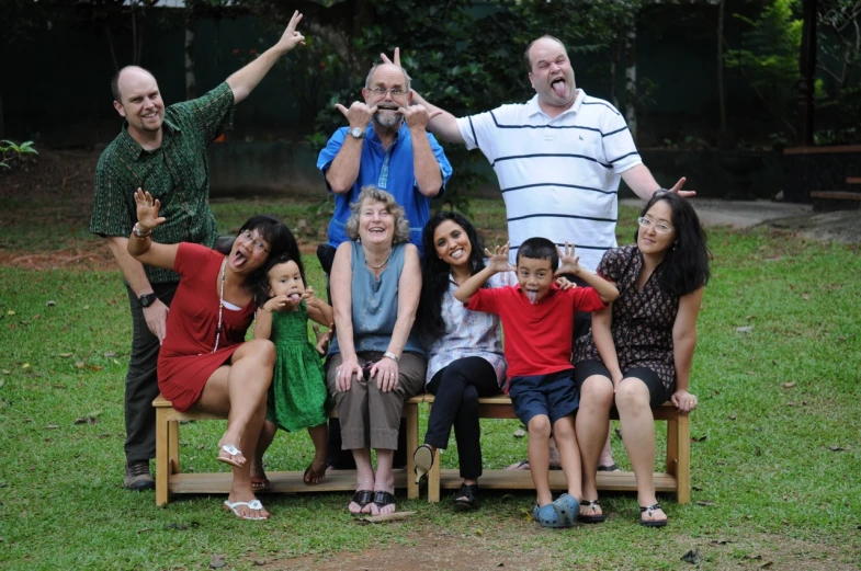 some people standing and sitting on a small bench