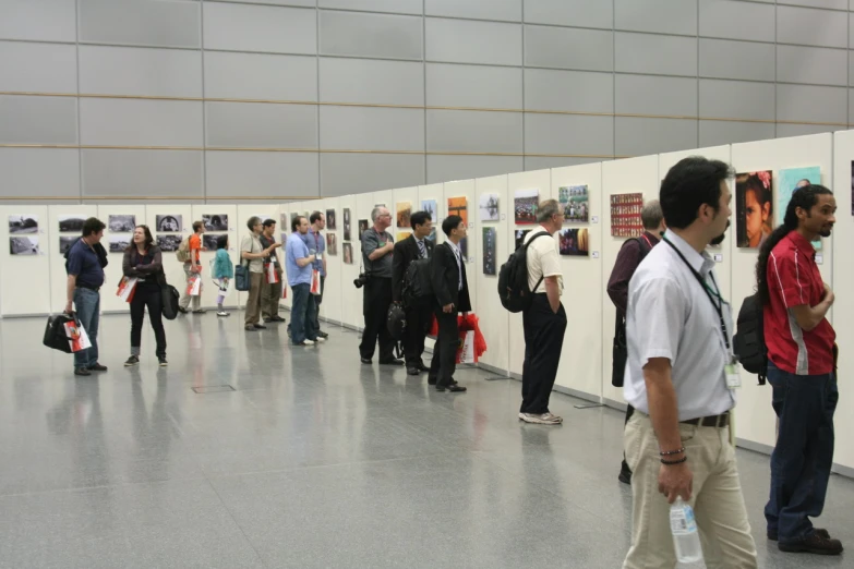 people looking at art work hanging on a wall