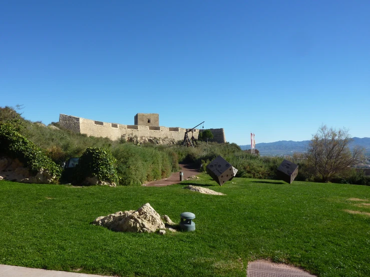 a castle like building overlooks an almost empty lawn