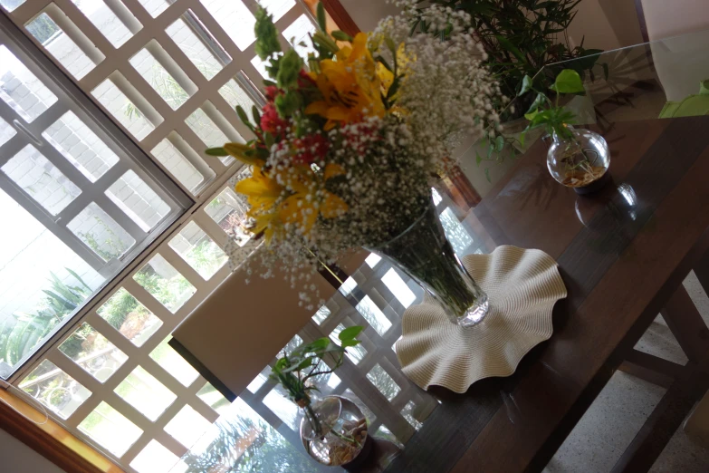 flowers in vases with water and flowers sitting on table