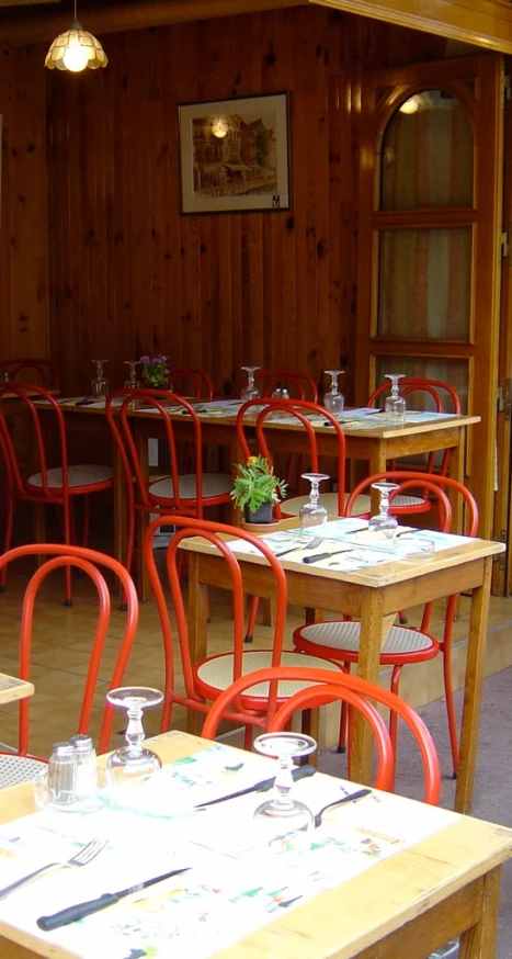 some tables with red chairs around them