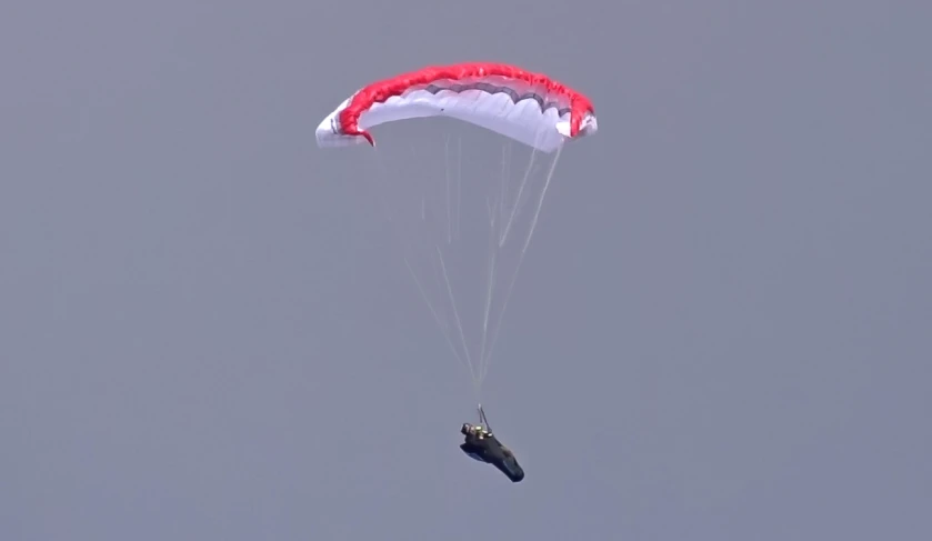 a person parasails in the sky while holding on to a parachute