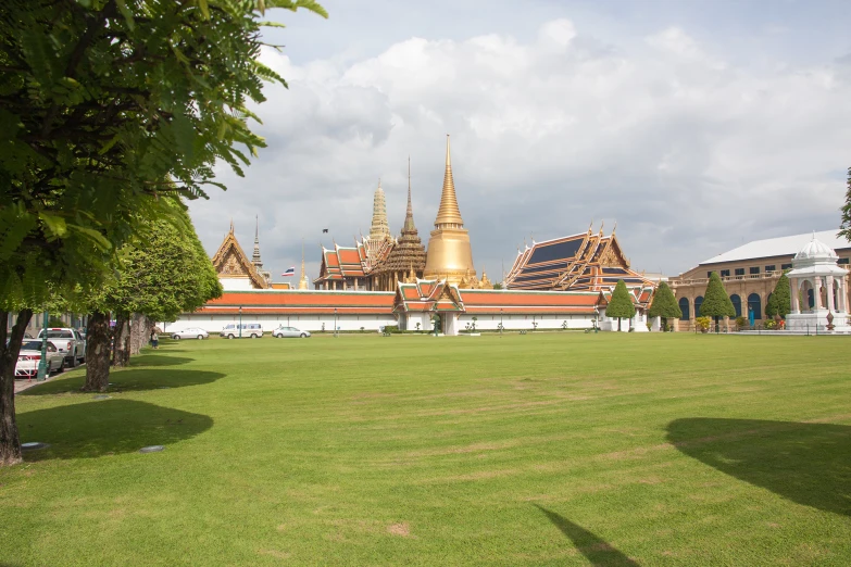 the grass is green and the large building is very tall