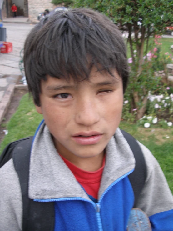 a child with black hair is outside near the street