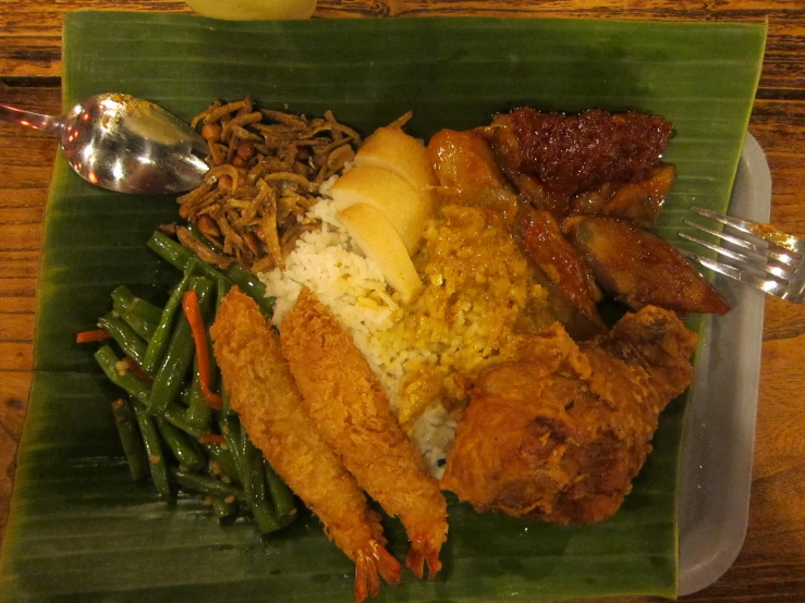 a large plate of food including some fried chicken and rice