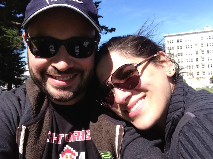 man with hat and sunglasses taking selfie of his friend