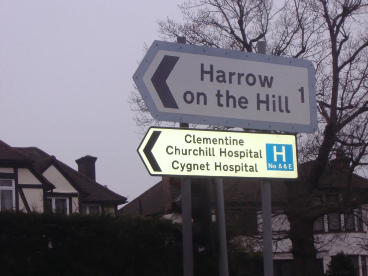 a street sign is pictured with the house in the background