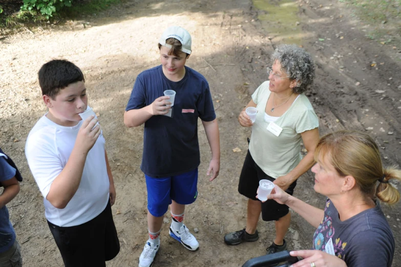 five people standing in the dirt with coffee