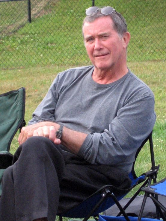 a man sitting in his camping chair near a dog