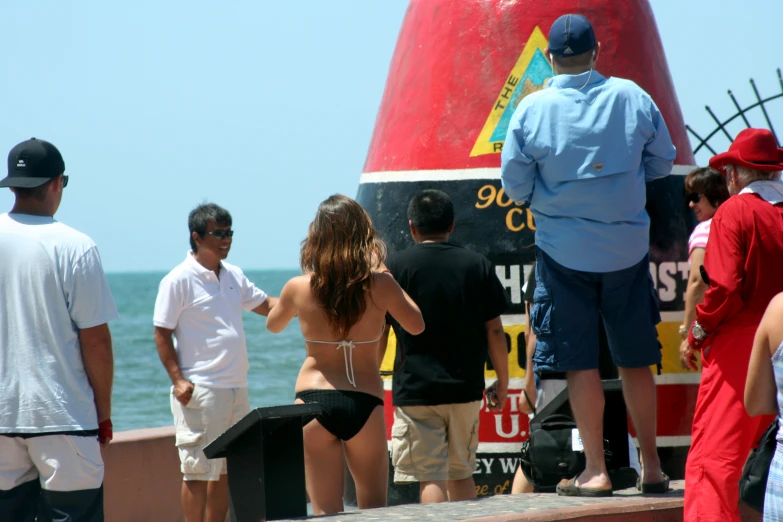 people stand on a dock and look at the ocean