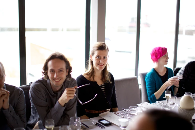 people sitting around a table with wine glasses on it