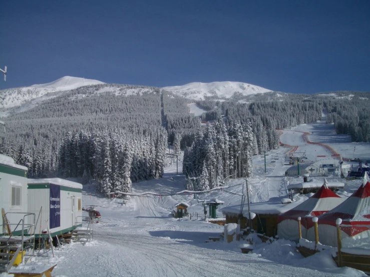 the resort is covered in snow and has trees and houses in the background