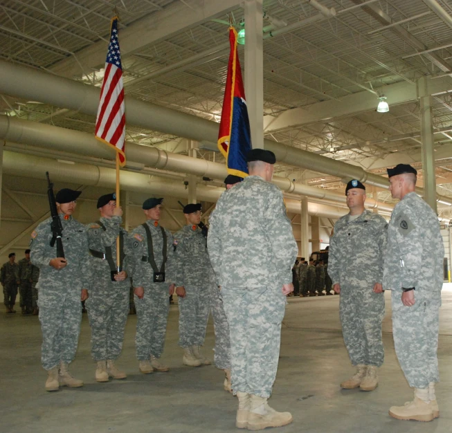 several soldiers standing with flags in a large room