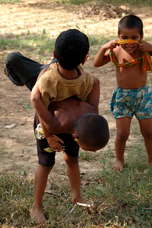 two boys are playing with the ball in the yard