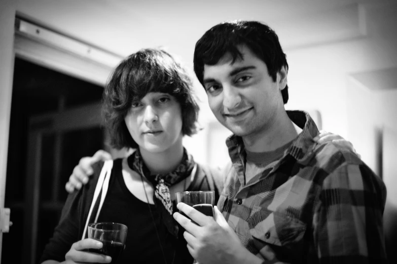 a black and white image of two people holding wine glasses
