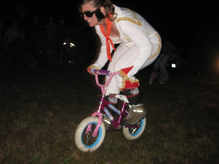 a  rides a toy bike and costumed with an elvis presley outfit