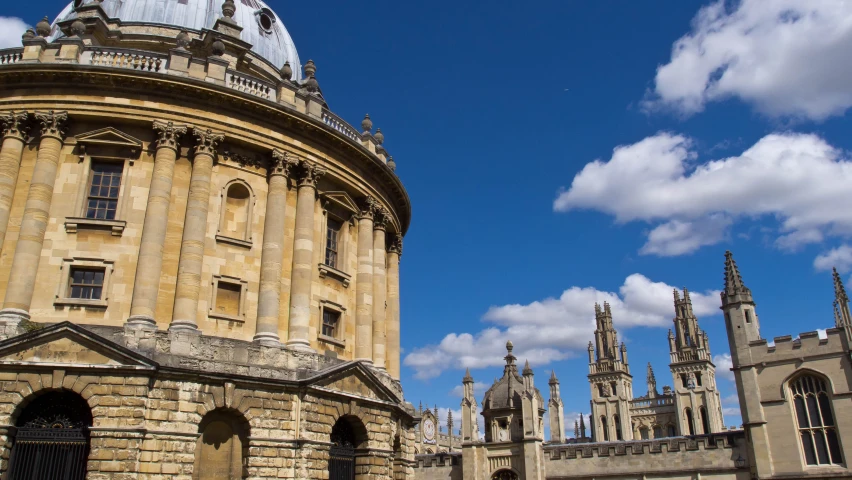 two buildings with spires and blue sky in the background