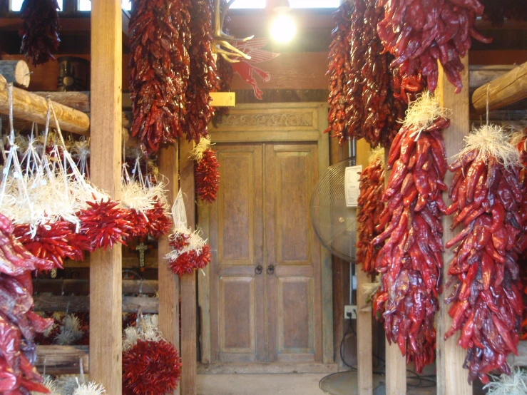 rows of  red peppers hang in a market