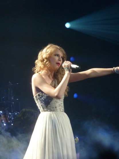 a woman in a white dress is on stage