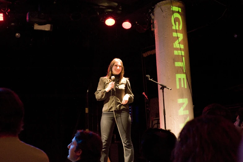 a woman in black stands in front of a crowd