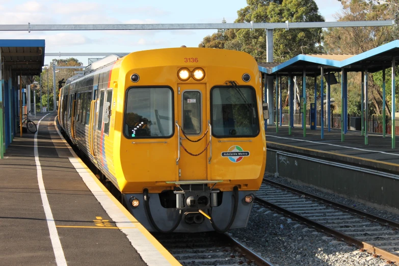 a train pulling into the station with lights on