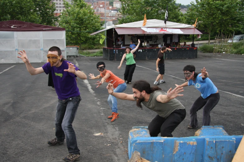 some people are playing with skate boards in a parking lot