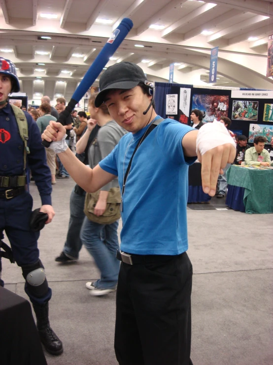 a young man with a baseball bat gives the thumbs up