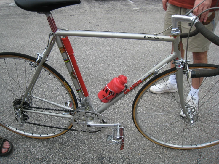 the bike is parked by the person wearing white shoes