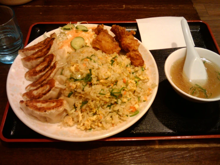 the bowl is full of rice and meat next to the drink