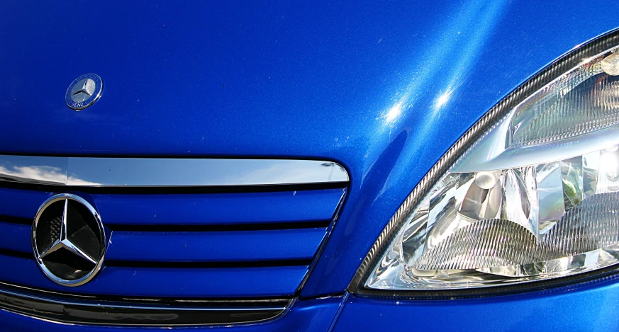 the headlight and front of a blue mercedes benz