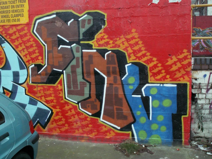 a graffittied wall with letters that say klw