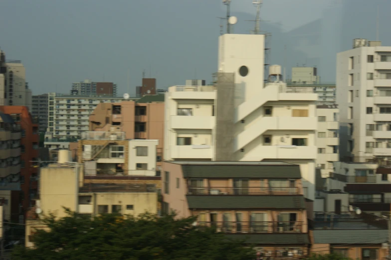 a tall white building with lots of windows next to a city