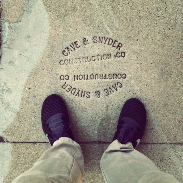 someone is standing near a large cement sign