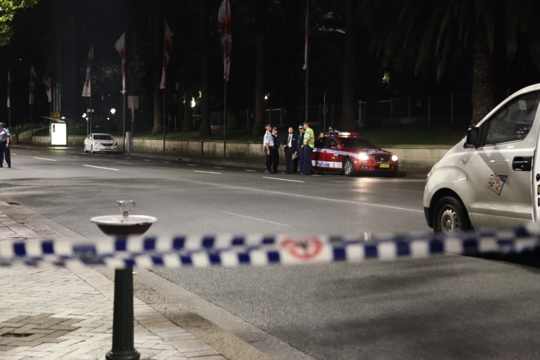 police on the side of the road with a corded off area in the background