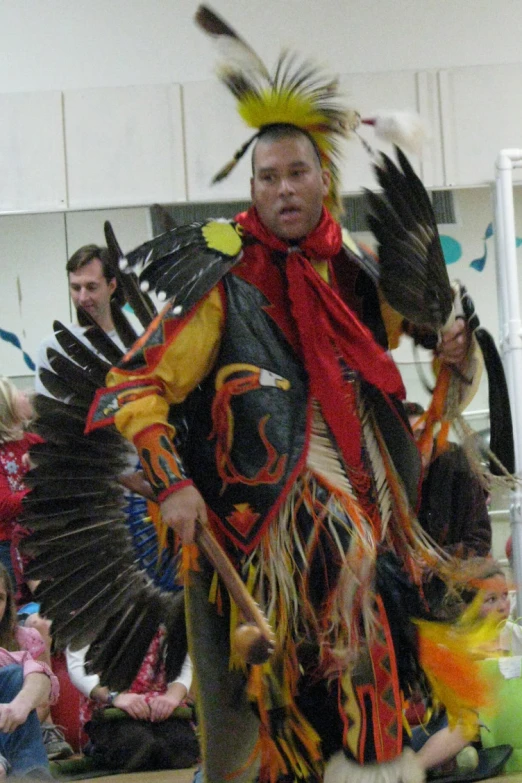 a man dressed in a native american style outfit and with a long arrow