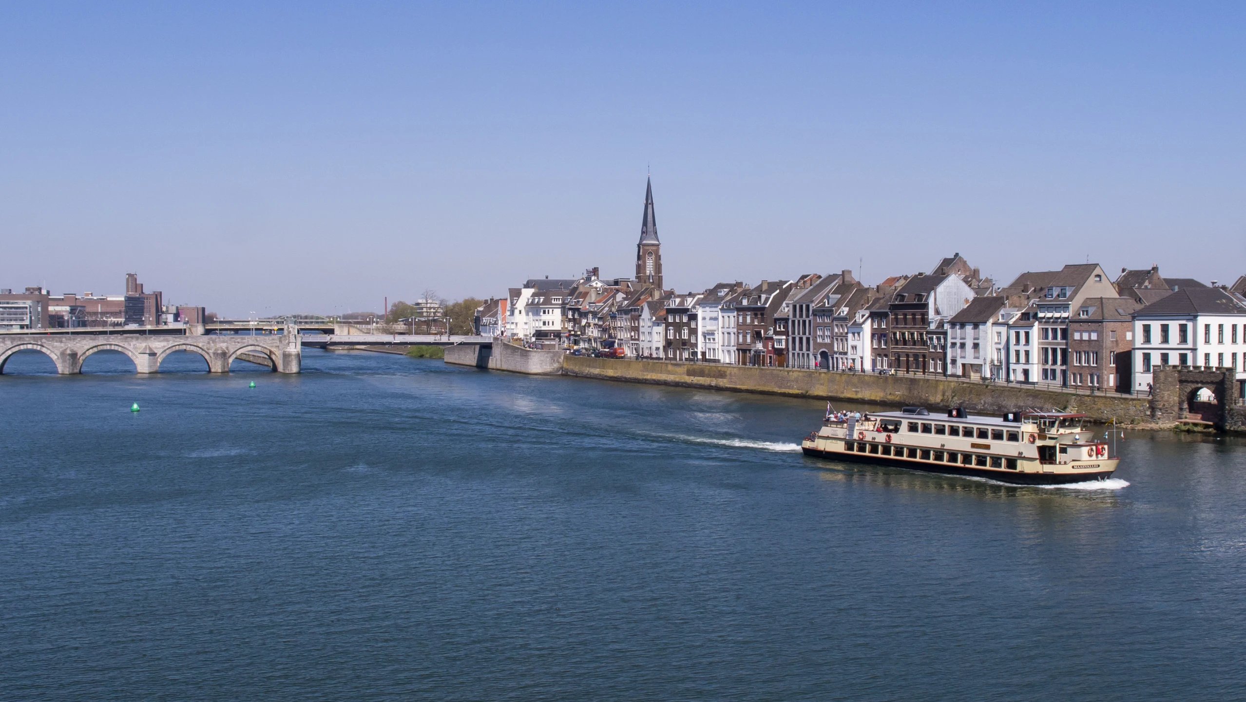 a boat sails by the shore in a city