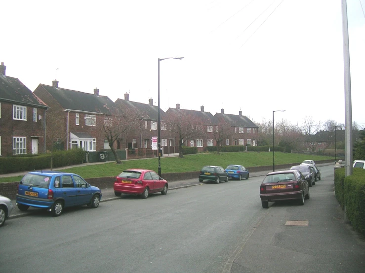 a line of parked cars and their parked motorcycles