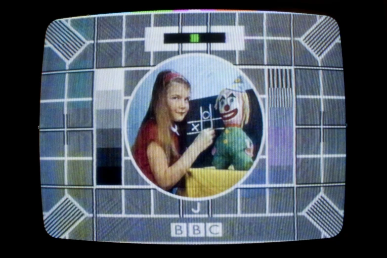 a television screen shows a woman holding up a camera